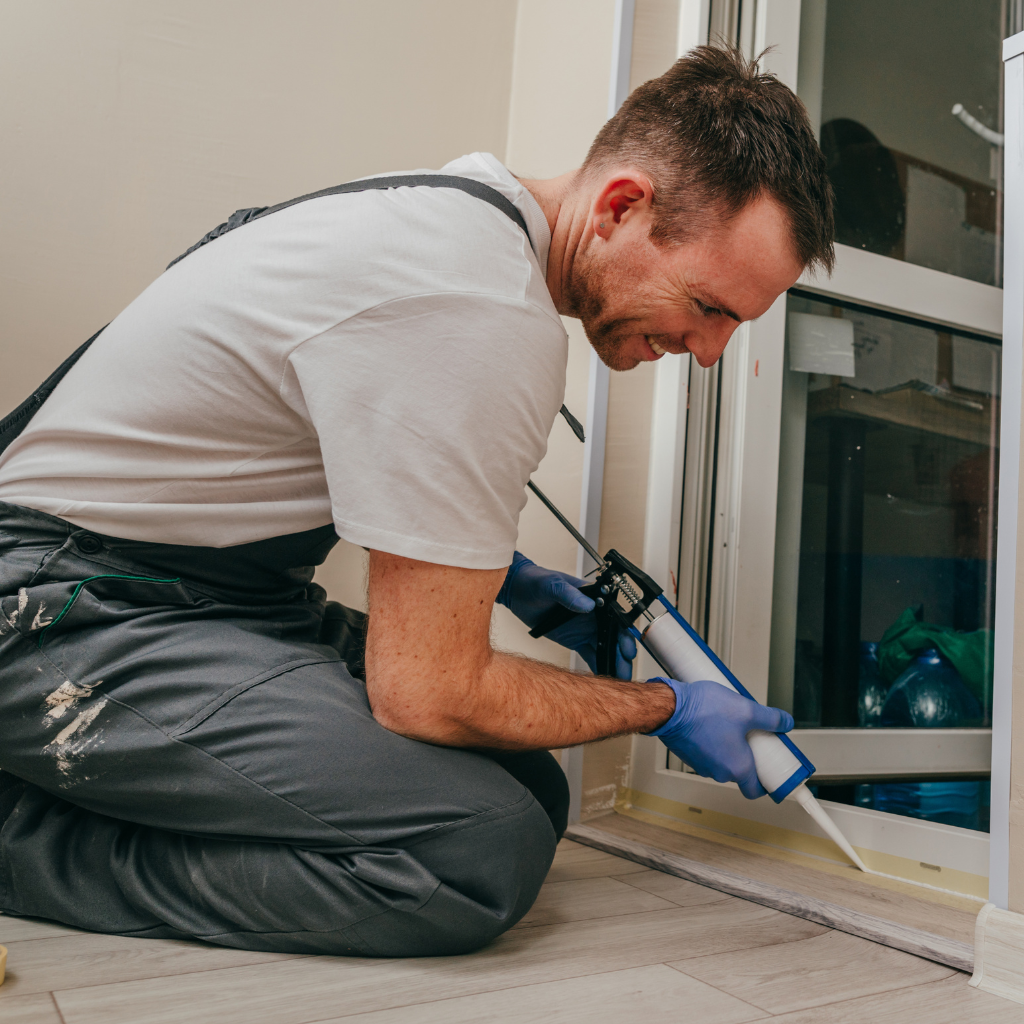 Construction worker air sealing a home